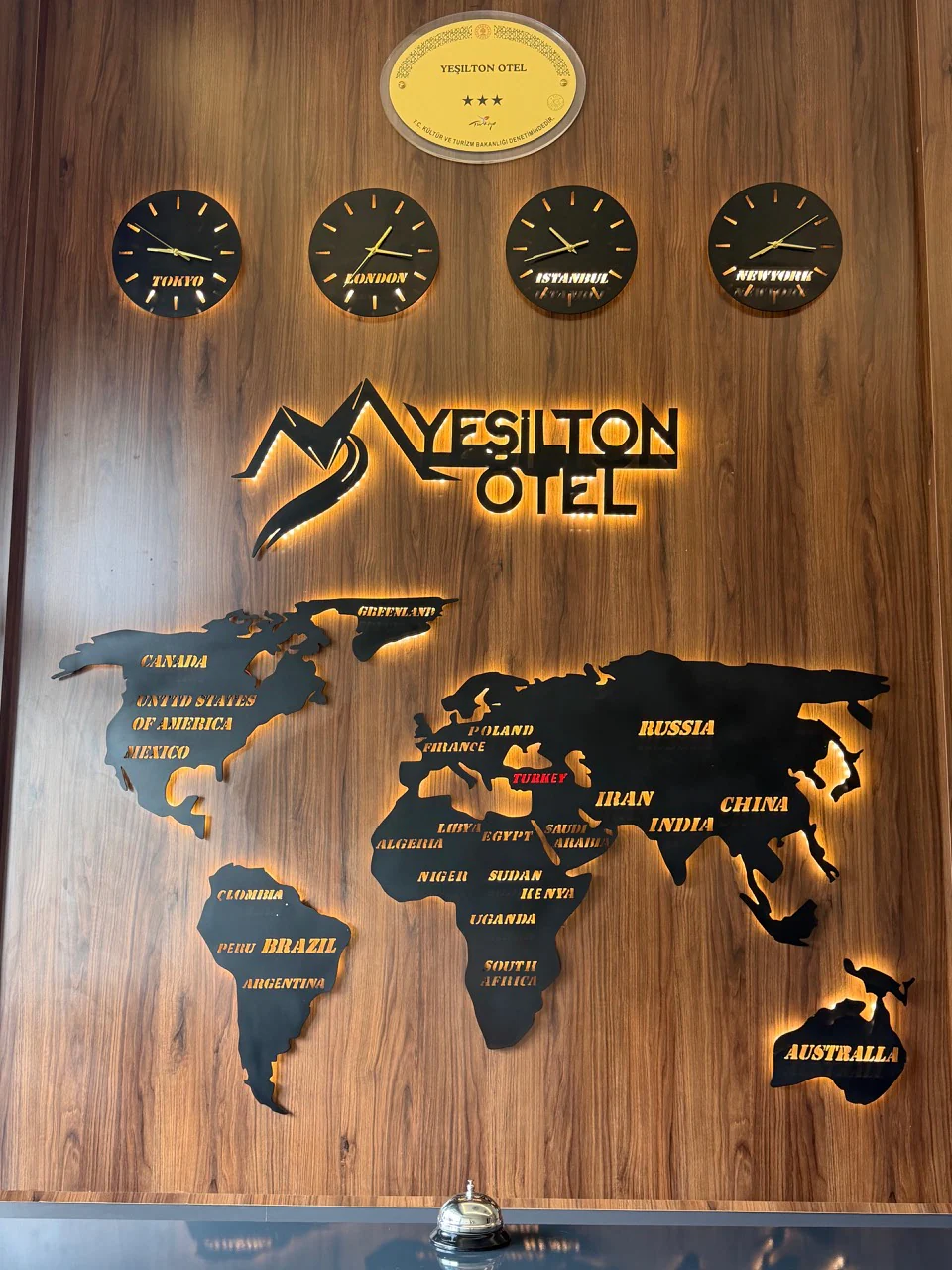Yeşilton Hotel resepsiyonundaki üç yıldız belgesi ve aydınlatmalı otel logosu